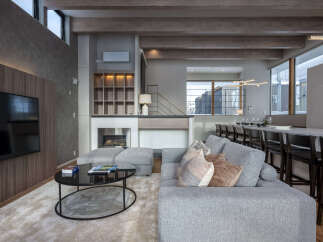 Experience modern luxury in this spacious living area, featuring a sleek fireplace, built-in shelving, and a large flat-screen TV.