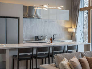 Experience modern living in this stunning kitchen and living area, featuring a sleek, integrated refrigerator and a spacious quartz countertop island perfect for entertaining.