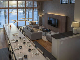 Experience luxury living in this stunning modern home, featuring a spacious open-plan living and dining area with a long dining table set for a feast.
