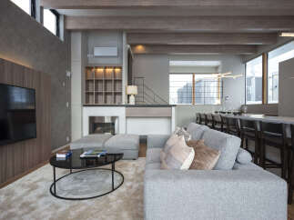 Experience modern luxury in this spacious living area, featuring a sleek fireplace, integrated entertainment system, and comfortable sectional sofa.
