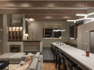 Experience modern luxury in this spacious open-plan living area, featuring a cozy fireplace and comfortable sectional sofa.