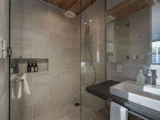Experience modern luxury in this stunning bathroom featuring a spacious walk-in shower with elegant tilework and a sleek rainfall showerhead.