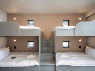 This modern hotel room features a unique bunk bed setup, perfect for families or groups traveling together.