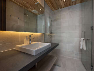 Experience modern luxury in this beautifully designed bathroom, featuring a sleek vanity with a vessel sink and a contemporary faucet.
