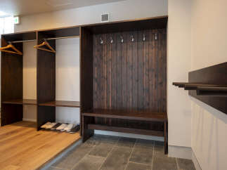 This entryway features a stylish dark wood built-in closet and bench, perfect for organizing shoes and coats.