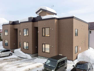 Experience modern living in this multi-unit property, featuring a distinctive brick facade and ample snow-covered grounds.