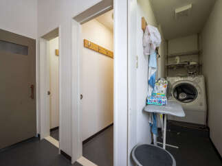 Discover a functional laundry area featuring a modern washing machine and an ironing board, perfect for managing household chores.