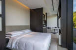 Experience luxurious comfort in this modern hotel room, featuring a plush king-sized bed with crisp white linens and a stylish upholstered headboard.