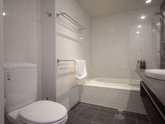Experience modern comfort in this well-appointed bathroom, featuring a sleek toilet and a relaxing bathtub perfect for unwinding.