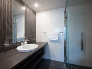 Experience modern luxury in this sleek bathroom featuring a spacious vanity with a vessel sink and a contemporary faucet.