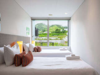 Experience comfort and style in this modern bedroom featuring two twin beds, perfect for accommodating guests or a family.