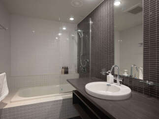 Experience modern comfort in this well-appointed bathroom, featuring a sleek vanity with a vessel sink and a spacious bathtub.