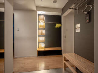 Discover a welcoming entryway featuring a stylish wooden bench perfect for removing shoes.