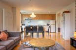 Experience modern living in this open-concept apartment, featuring a sleek kitchen with ample cabinet space and a dining area perfect for entertaining.