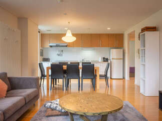 Experience modern living in this open-concept apartment, featuring a sleek kitchen with ample cabinet space and a dining area perfect for entertaining.