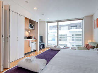 Experience modern urban living in this stylish studio apartment, featuring a compact kitchenette with essential appliances and ample storage.