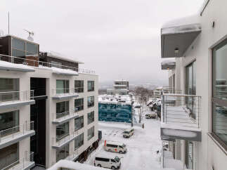 Experience modern living in this stunning apartment complex, featuring sleek architecture and spacious balconies perfect for enjoying the winter landscape.