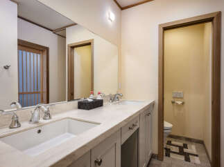 This modern bathroom features a spacious double vanity with elegant stone countertops and sleek chrome fixtures.