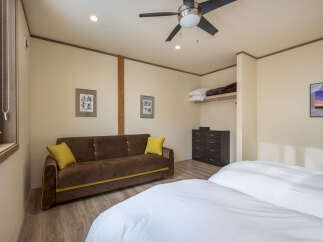 Discover comfort and style in this inviting bedroom, featuring a plush brown sofa with vibrant yellow accents, perfect for relaxation.