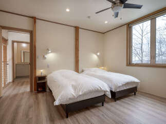 This inviting bedroom features two comfortable beds dressed in crisp white linens, perfect for a restful night's sleep.