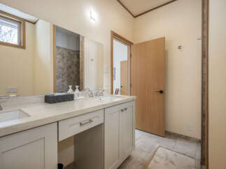 This modern bathroom features a spacious vanity with dual sinks and ample counter space, perfect for busy mornings.