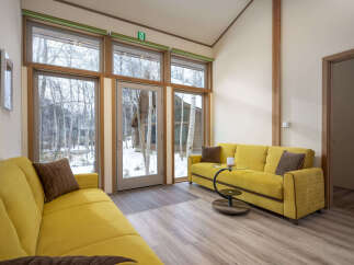 Experience cozy living in this charming room featuring two vibrant yellow sofas, perfect for relaxing.