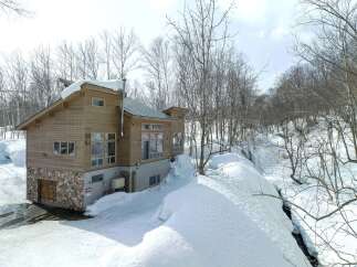 Experience the charm of this wooden chalet nestled in a serene, snow-covered landscape.