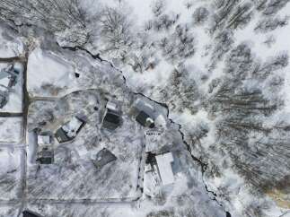 Discover this winter wonderland retreat featuring multiple modern homes nestled amongst snow-covered trees.