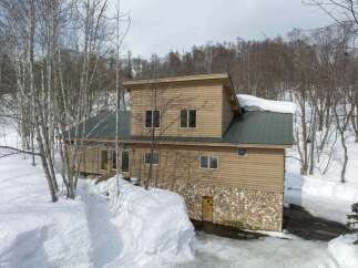 Nestled amidst a serene winter landscape, this charming wooden house offers a cozy retreat.