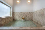 Experience ultimate relaxation in this serene bathroom featuring a spacious soaking tub with a gentle waterfall feature.