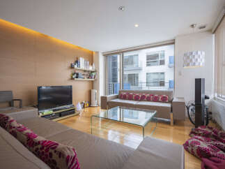 Experience modern living in this stylish apartment featuring a spacious living area with a sleek entertainment center and a comfortable sectional sofa.