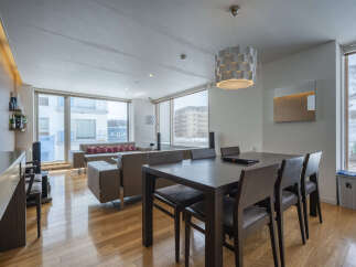 Experience modern living in this spacious apartment featuring a combined living and dining area with large windows offering scenic views.