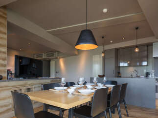 Experience modern living in this stylish dining area, featuring a sleek wooden table set for six and contemporary black chairs.