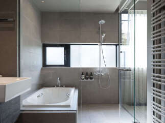 Experience modern luxury in this stunning bathroom featuring a sleek bathtub and a separate glass-enclosed shower.