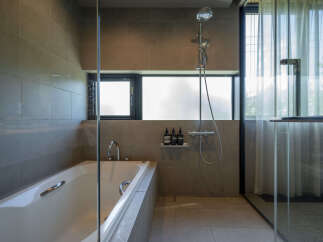Experience modern luxury in this stunning bathroom featuring a deep soaking tub and a separate glass-enclosed shower.