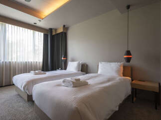 Experience modern comfort in this hotel room featuring two plush twin beds, perfect for a restful stay.