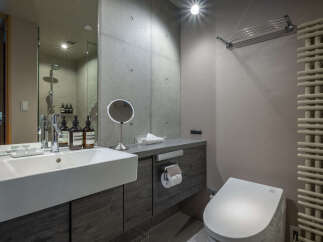 Experience modern luxury in this meticulously designed bathroom, featuring a sleek vanity with a vessel sink and premium Aesop toiletries.