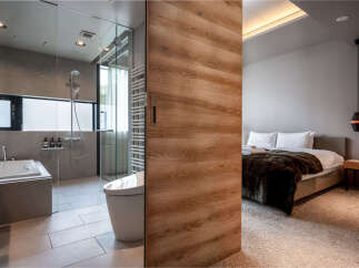 Experience modern luxury in this stunning hotel room, featuring a sleek bathroom with a deep soaking tub and a separate shower.