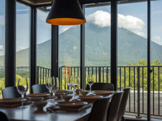 Experience breathtaking mountain views from this elegant dining room, featuring a beautifully set table perfect for intimate gatherings.