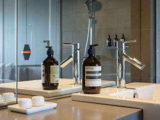 Experience luxury in this modern bathroom featuring a sleek double vanity with chrome faucets.