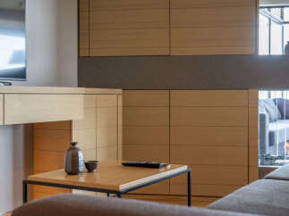 Experience modern living in this stunning property featuring a sleek entertainment center with ample storage and a contemporary fireplace.