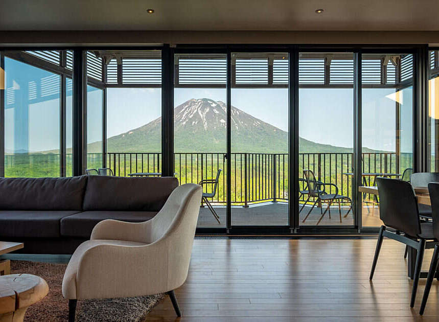 Experience breathtaking panoramic views of a majestic snow-capped mountain from this luxurious living space.