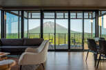 Experience breathtaking panoramic views of a majestic snow-capped mountain from this luxurious living space.