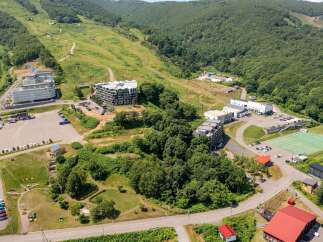 Discover this expansive resort nestled amidst lush green mountains, perfect for outdoor enthusiasts.