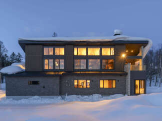 Experience luxury mountain living in this stunning modern home, perfectly situated amidst a serene winter landscape.