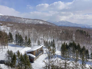 Experience luxury mountain living in this stunning contemporary home, nestled amidst a serene winter landscape.