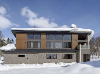 Experience luxury mountain living in this stunning modern home, perfectly situated amidst a serene winter landscape.