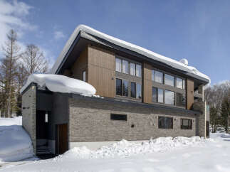 Experience luxury mountain living in this stunning contemporary home, perfectly situated amidst a snowy landscape.