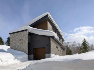 Experience luxury living in this stunning modern home, perfectly situated in a serene, snow-covered landscape.