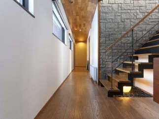 Experience modern living with this stunning interior featuring a sleek wooden ceiling and a unique stone accent wall.